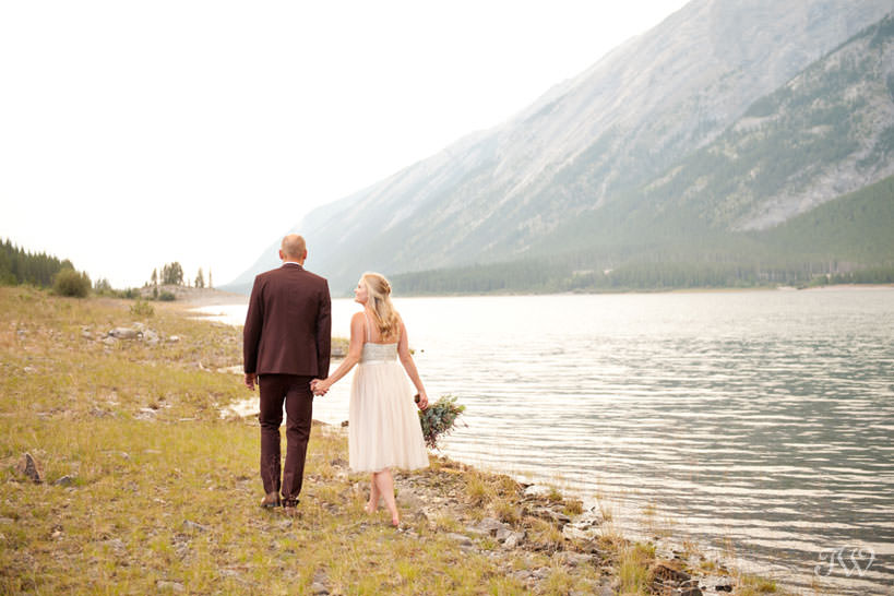 Couple on the shore of Spray Lakes captured by Calgary wedding photographer Tara Whittaker